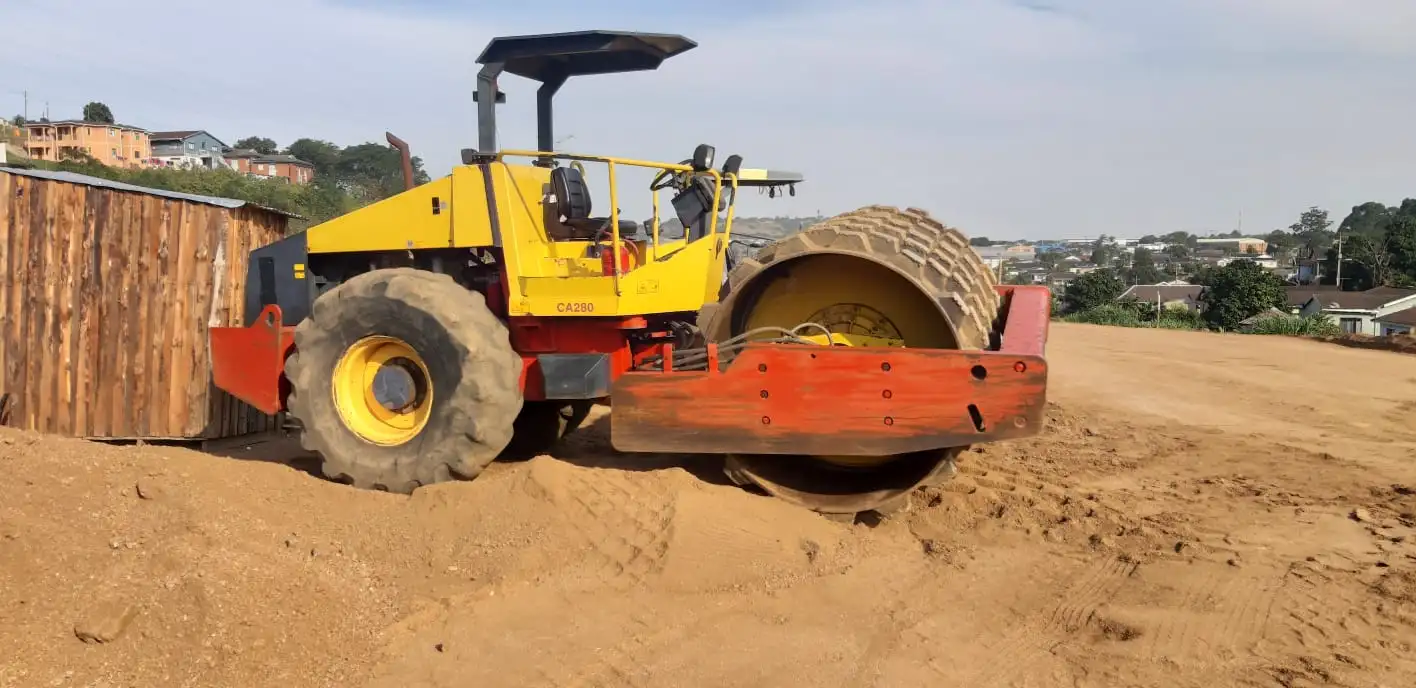 Sherry's smooth drum roller standing on a sand platform above a Durban hillside suburb