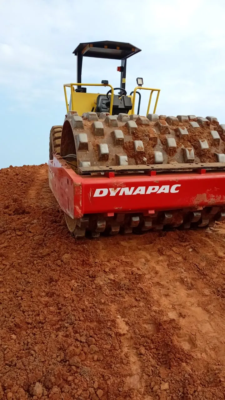 Sherry's 12 ton pad-foot roller on freshly placed red fill, pads biting into the layer