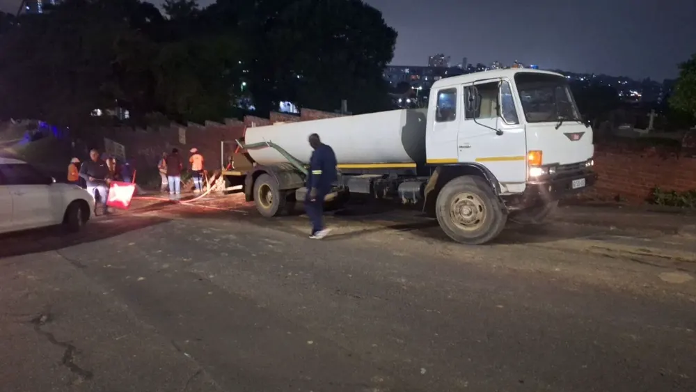 Sherry's water tanker and crew working a road job after dark