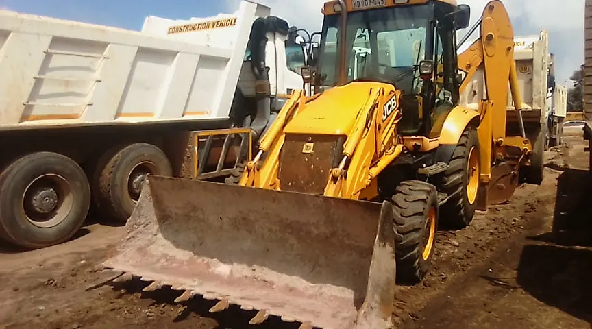 Sherry's JCB TLB loading out alongside site tipper trucks